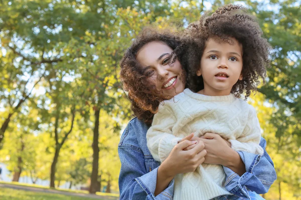 Mother lifting her smiling child outdoors